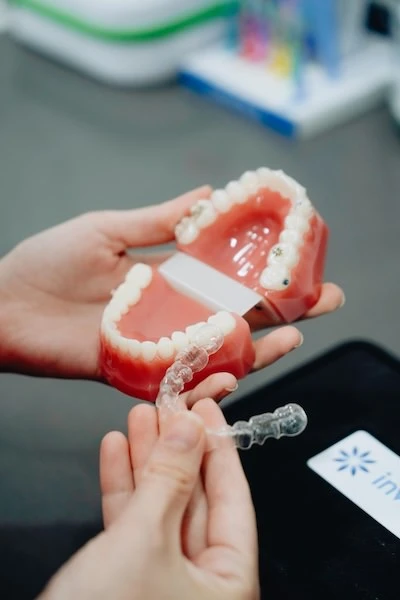 Alineador transparente Invisalign junto a un modelo dental en el Centro Odontológico Miguel González, clínica dental en Oviedo